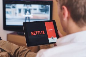 man watching netflix on table; maximizing ROI with localization translation solutions