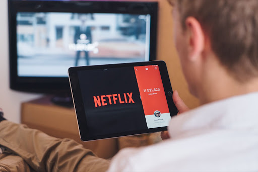 man watching netflix on table; maximizing ROI with localization translation solutions