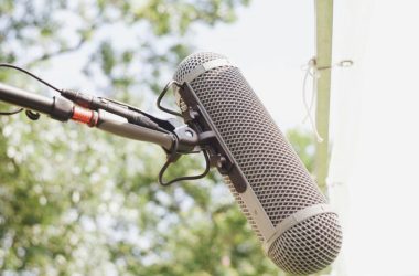 A microphone attached to a pole with trees in the background