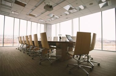 oval brown wooden conference table and chairs inside conference room