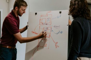 man drawing on dry-erase board