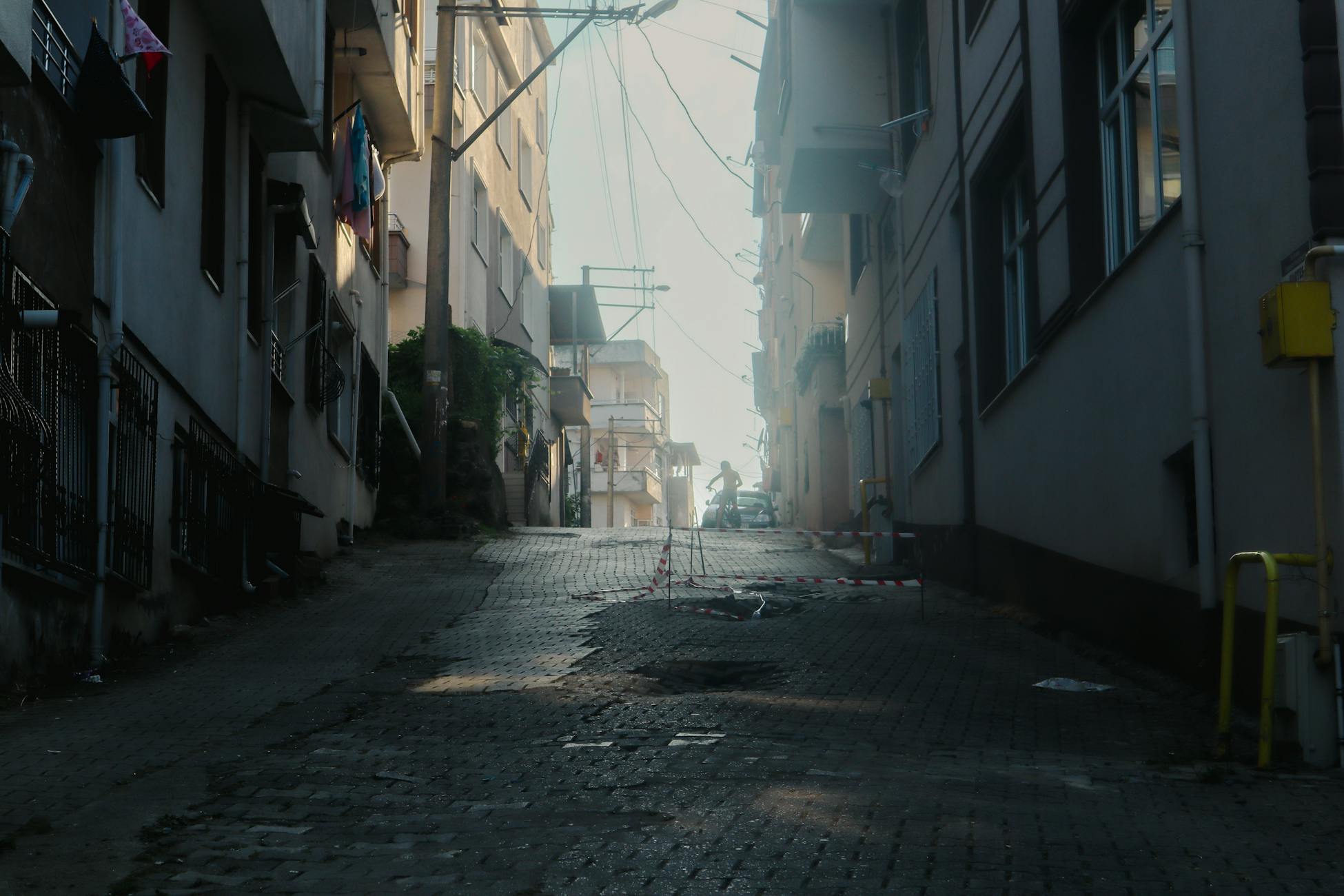 A narrow city alleyway captured with a moody morning light, showcasing urban architecture.