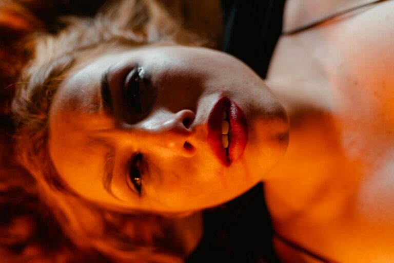Close-up portrait of a woman with dramatic lighting, depicting intense emotion.