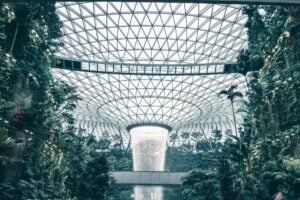 Lush indoor garden with impressive waterfall at Jewel Changi Airport, Singapore.