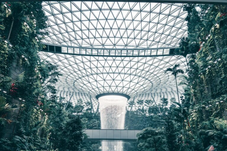 Lush indoor garden with impressive waterfall at Jewel Changi Airport, Singapore.
