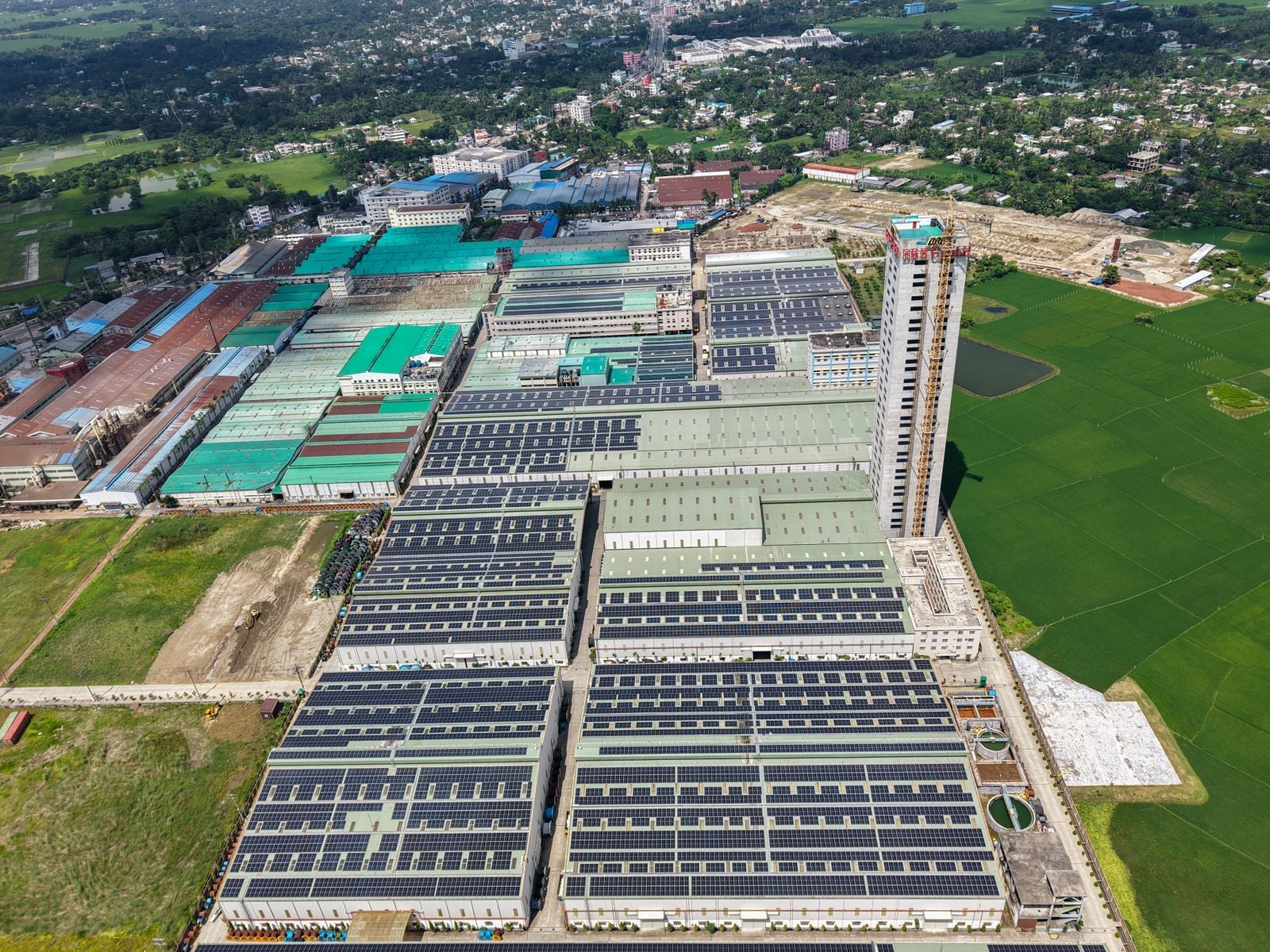aerial view of an industrial complex covered in solar panels