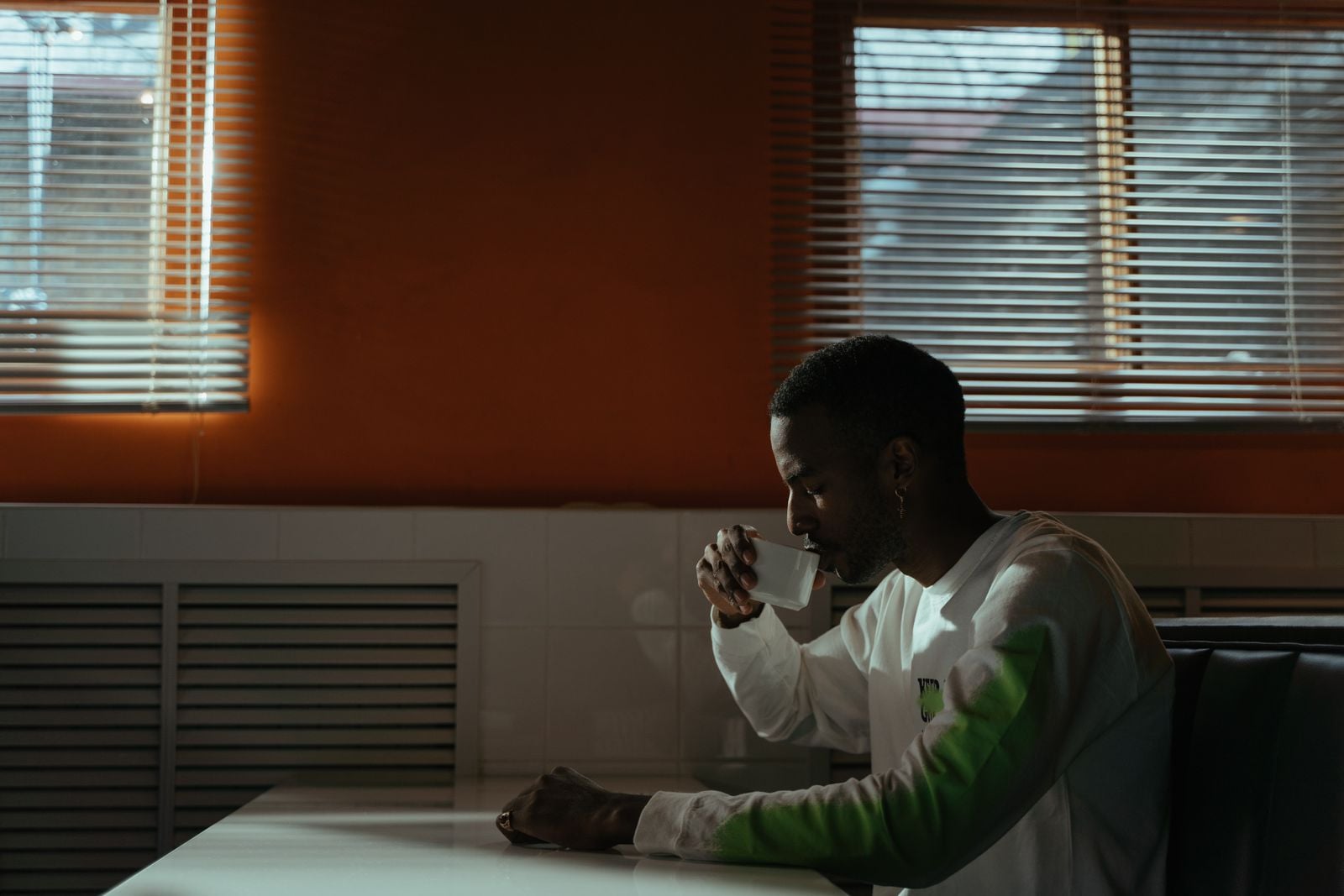 man seated in a cafe with a cup of coffee
