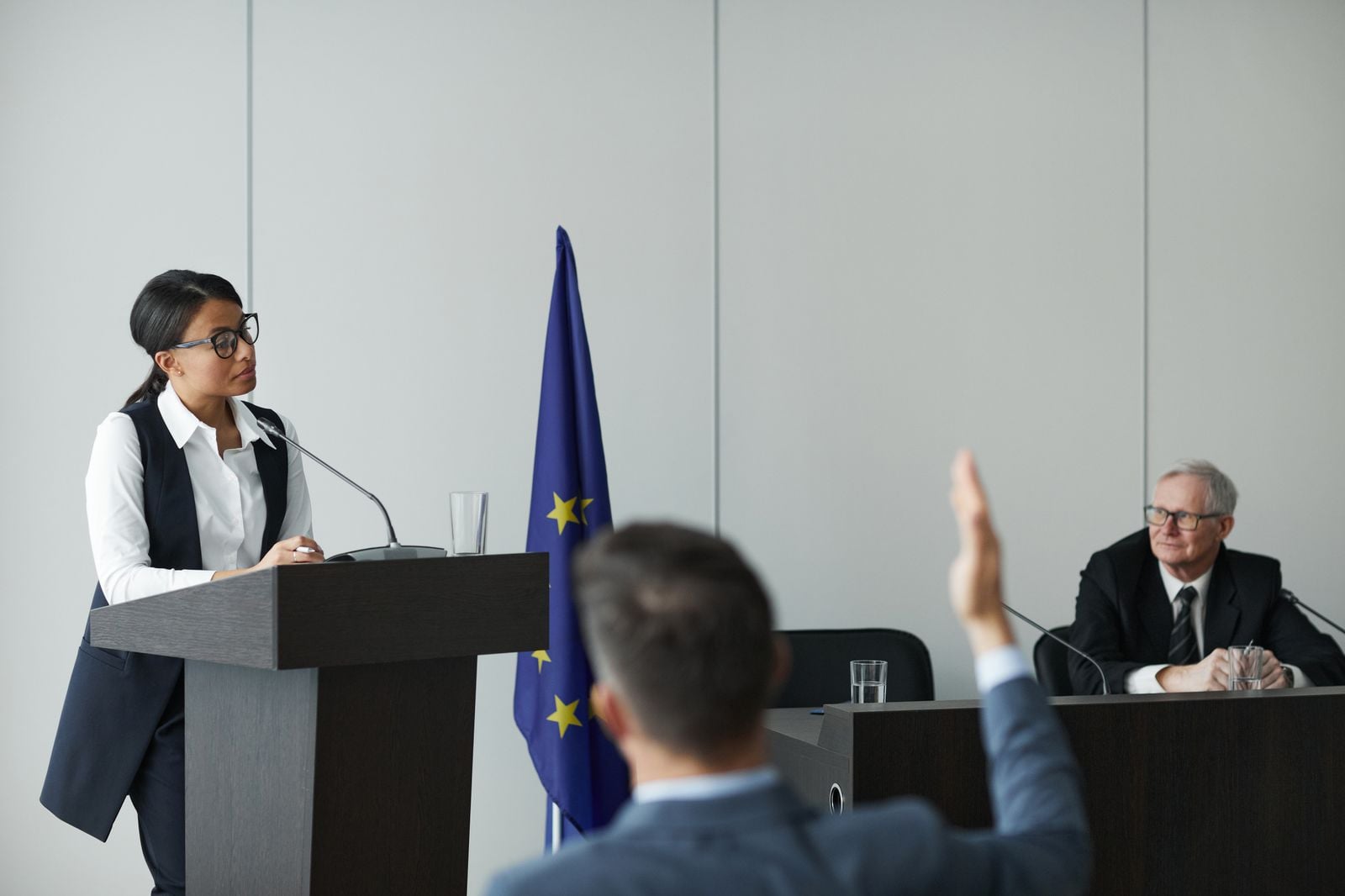Official speaking at a rostrum during a public meeting