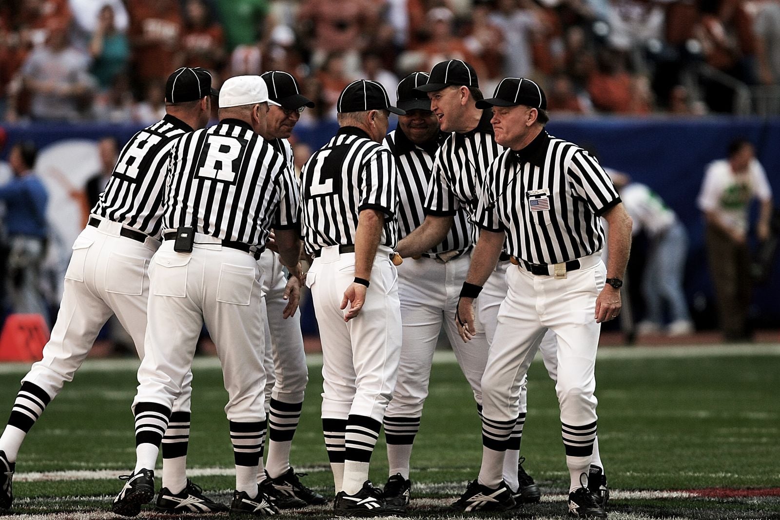 Silhouetted football referees standing on a field