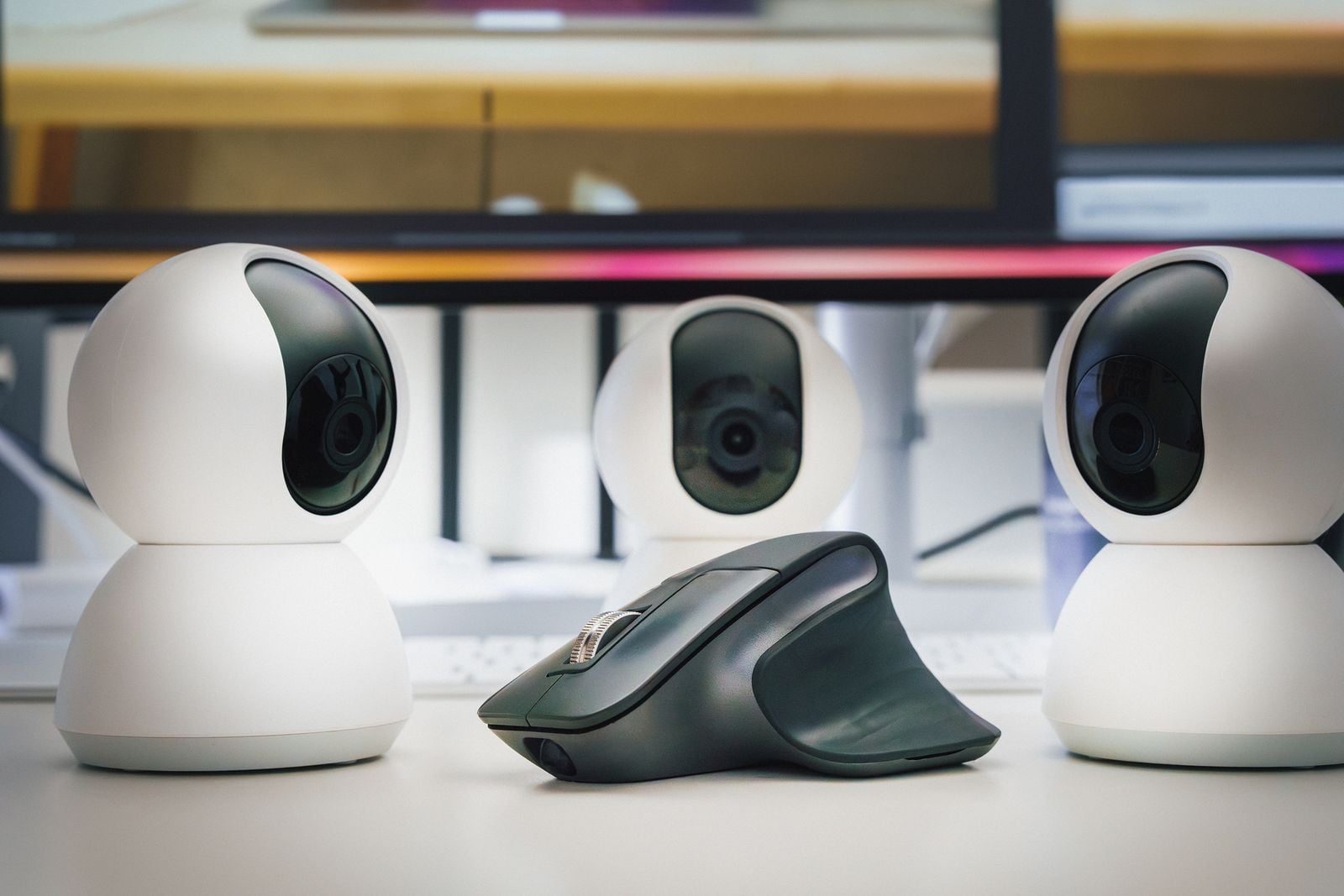 Three webcams positioned beside a computer mouse