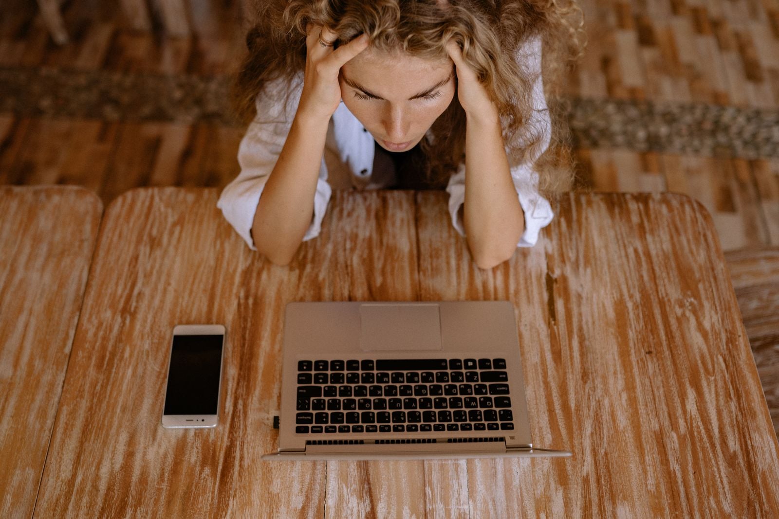Woman looking stressed while using a laptop