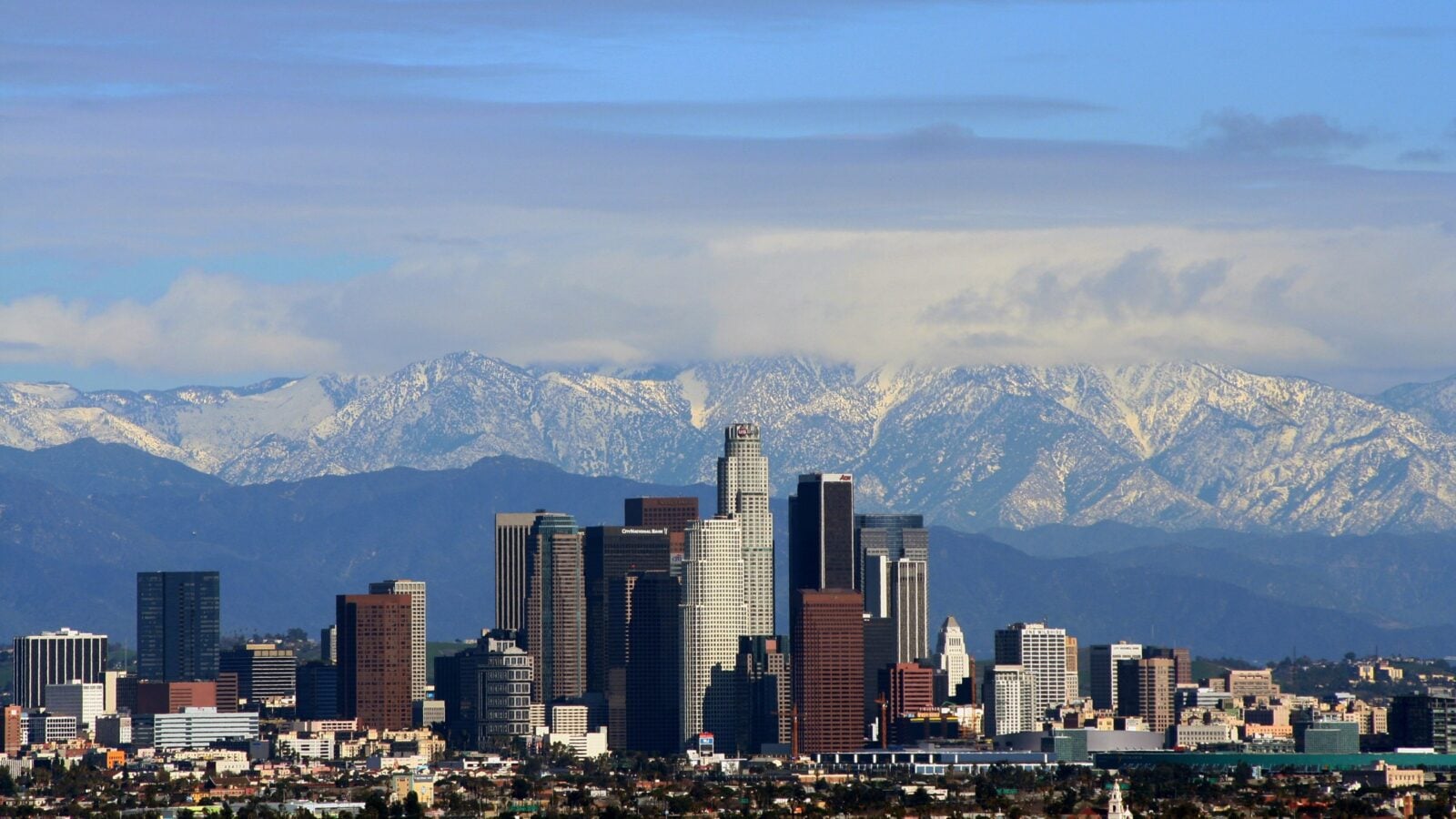 Downtown Los Angeles skyline with snow-capped San Gabriel Mountains behind
