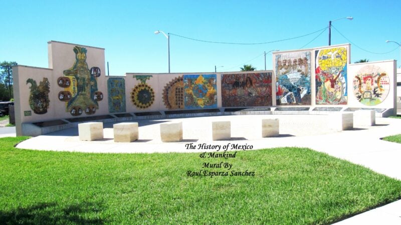 Street view in Harlingen, Texas, showing a mural and downtown buildings under a blue sky